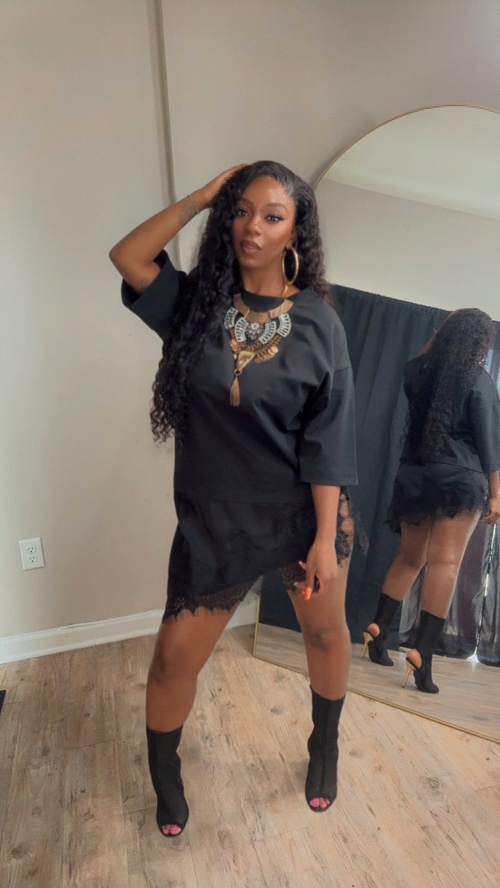 She is modeling a black oversized t-shirt lace dress with slits on the sides.