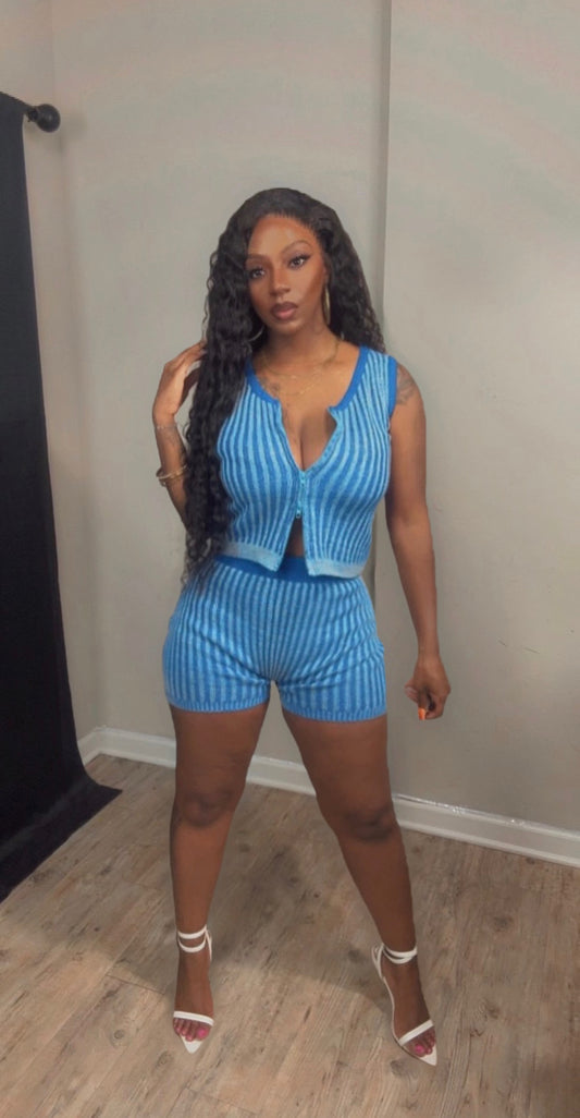 She is modeling a blue and white vertically striped two-piece set consisting of a sleeveless crop top and matching shorts.