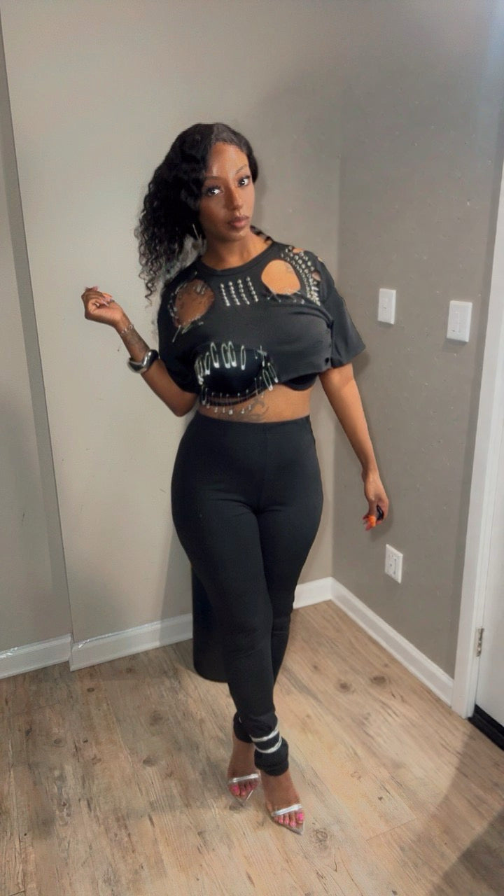 She is modeling a black two-piece outfit consisting of a short-sleeve crop top with cutouts and silver pins embellishments. (comes with pins that you apply yourself).