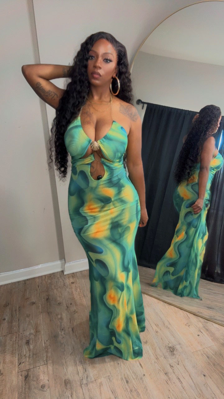 She is 5'2 wearing a floor-length green and yellow abstract print dress with a plunging neckline and a front keyhole cutout. 