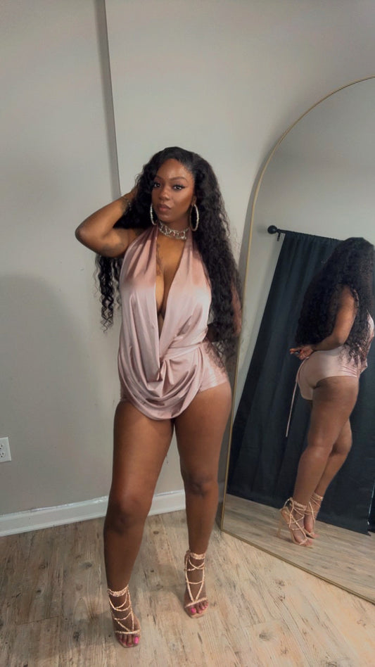 She is wearing a light mocha satin-like draped one-piece romper